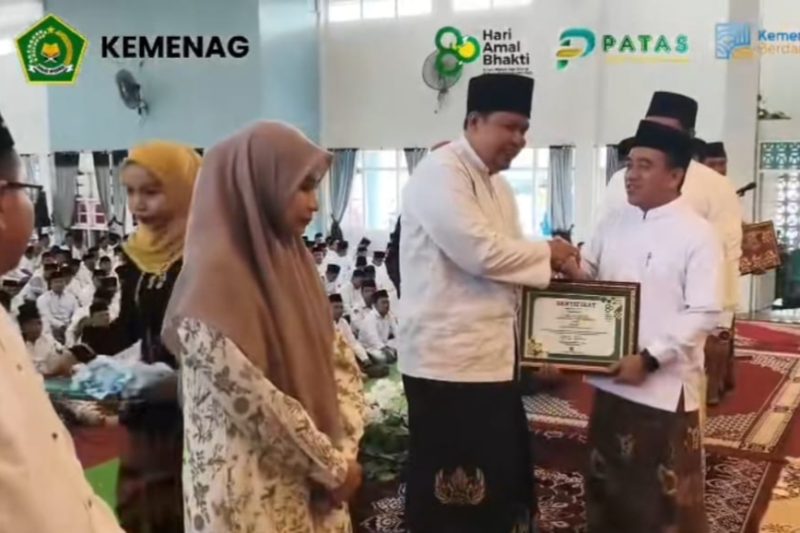 Momen Gus Abdul Adim Yasin (kiri) saat menerima sertifikat penghargaan Anugerah Penyuluh Agama dari Kepala Kantor Urusan Agama Sumenep. Senin (13/1/2026) di Graha Wicaksana Abdi Negara Kabupaten Sumenep. @suaradara.com/istimewa 
