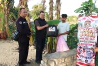 Kasi Humas Polreta Sumenep, Ipda Ach Putrawardana (tengah) didampingi anggota saat memberikan bantuan kepada warga dalam rangka memperingati Hari Ulang Tahun (HUT) ke-75 Humas Polri